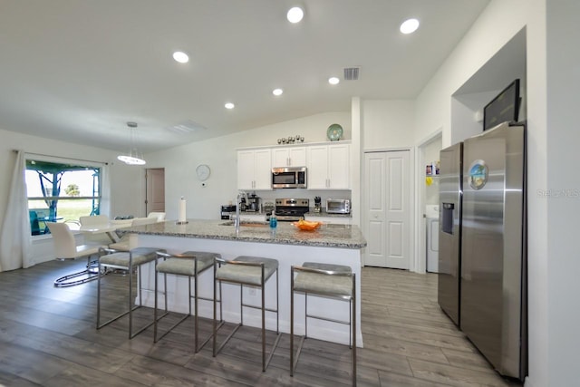 kitchen with vaulted ceiling, light hardwood / wood-style flooring, stainless steel appliances, and white cabinets