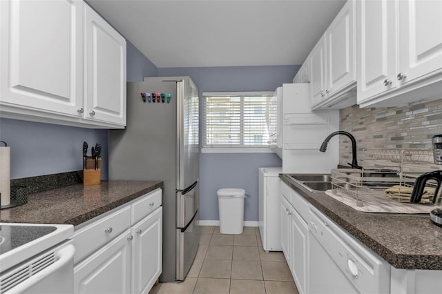 kitchen featuring sink, white cabinets, backsplash, light tile patterned floors, and white dishwasher