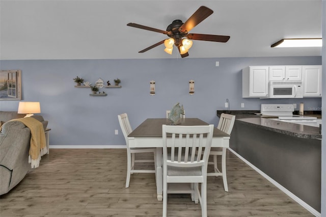 dining space featuring baseboards, light wood-style flooring, and ceiling fan