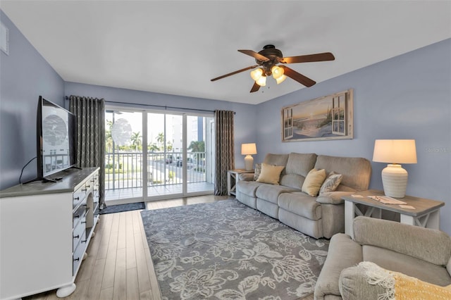 living room with light hardwood / wood-style floors and ceiling fan