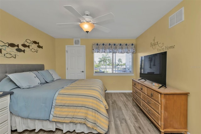 bedroom with baseboards, visible vents, wood finished floors, and a ceiling fan