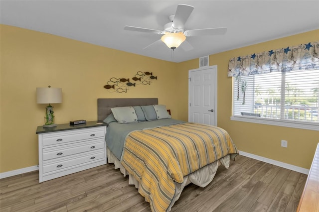 bedroom featuring ceiling fan, baseboards, light wood finished floors, and visible vents