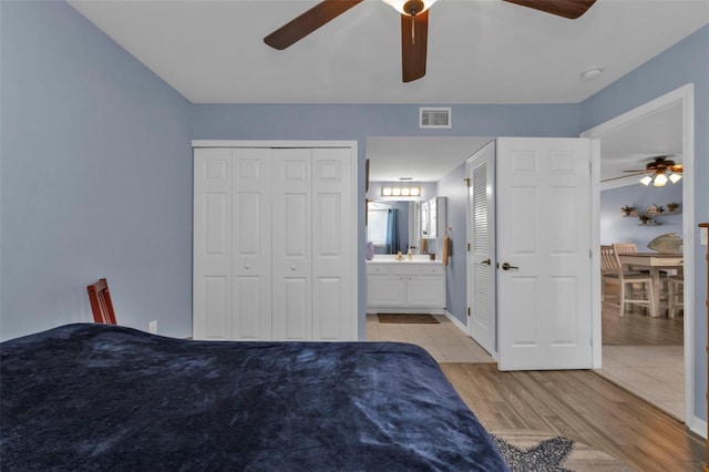 unfurnished bedroom with connected bathroom, light wood finished floors, baseboards, visible vents, and ceiling fan
