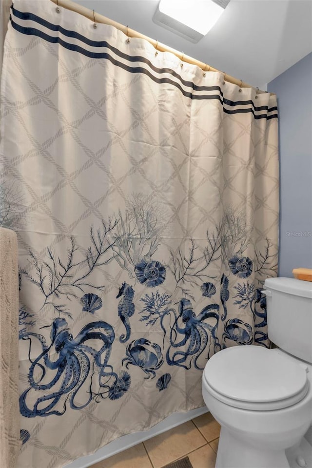 full bathroom with a shower with curtain, toilet, and tile patterned flooring