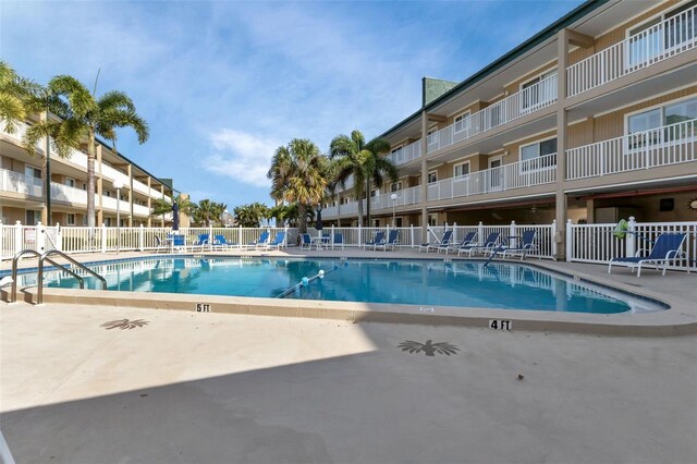 community pool with fence and a patio area