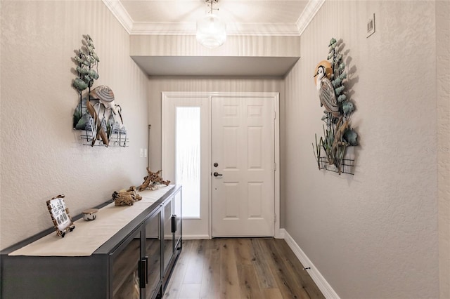 entryway with a textured wall, ornamental molding, baseboards, visible vents, and wood finished floors