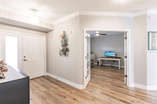 entryway featuring baseboards, light wood-style floors, and ornamental molding