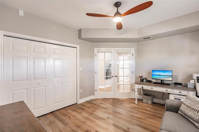 home office with baseboards, french doors, light wood-style floors, and a ceiling fan