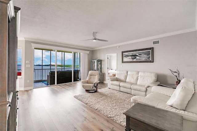 living area with ceiling fan, visible vents, crown molding, and wood finished floors
