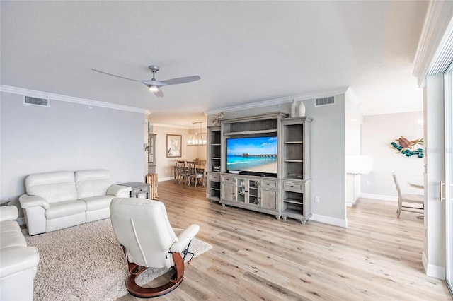 living room featuring crown molding, visible vents, a ceiling fan, and light wood finished floors