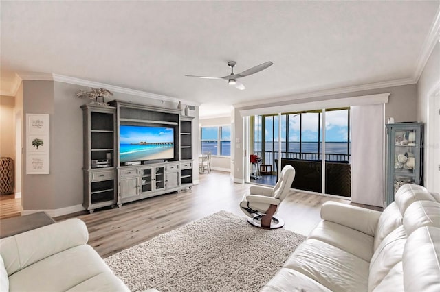 living room featuring crown molding, baseboards, wood finished floors, and a ceiling fan
