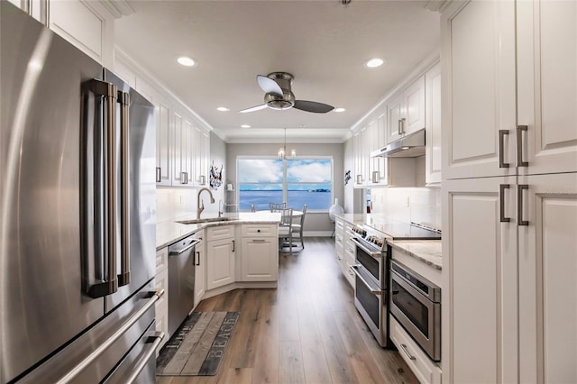 kitchen featuring hardwood / wood-style flooring, sink, stainless steel appliances, and white cabinets