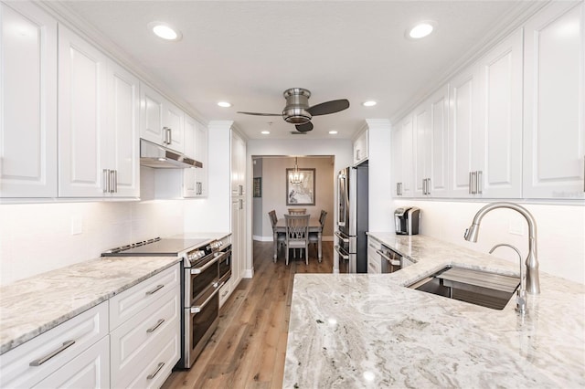 kitchen with ceiling fan, sink, white cabinetry, appliances with stainless steel finishes, and light hardwood / wood-style floors