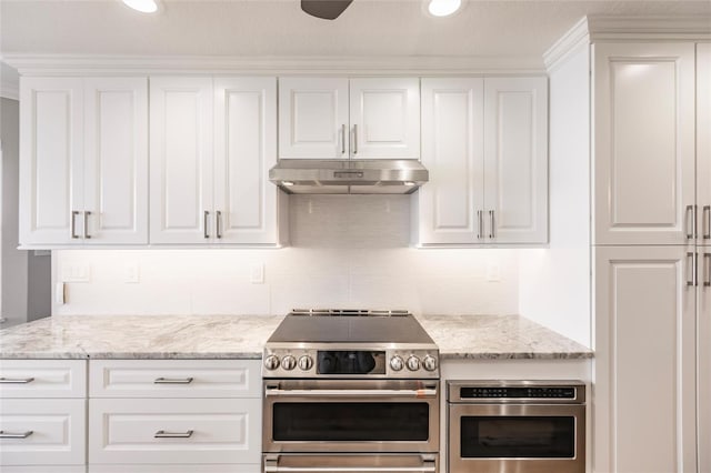 kitchen featuring white cabinets, stainless steel appliances, backsplash, light stone countertops, and ceiling fan