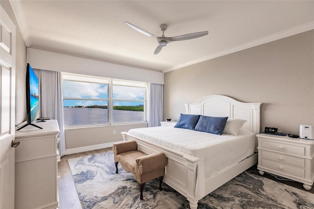bedroom with baseboards, ceiling fan, wood finished floors, and crown molding