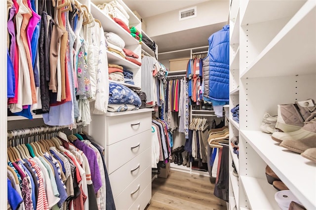 walk in closet with light hardwood / wood-style flooring