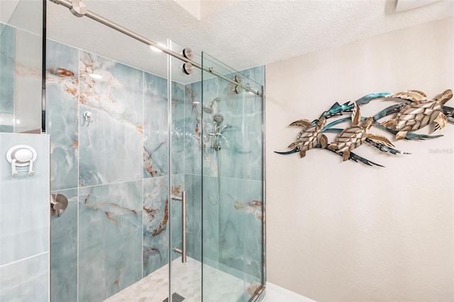 bathroom featuring a textured ceiling and a shower with shower door