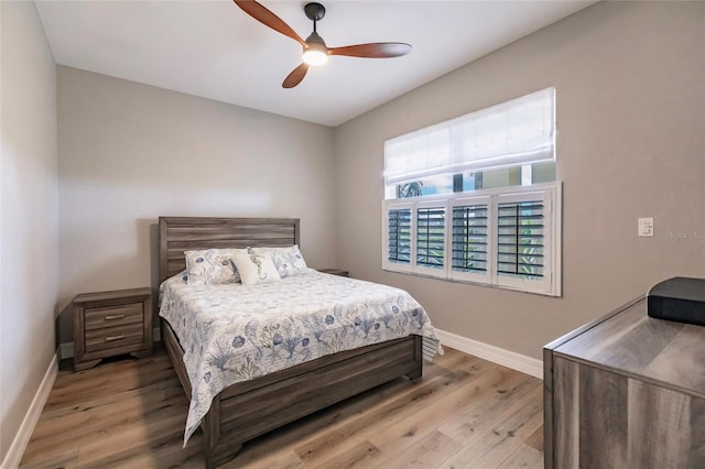 bedroom featuring a ceiling fan, baseboards, and wood finished floors