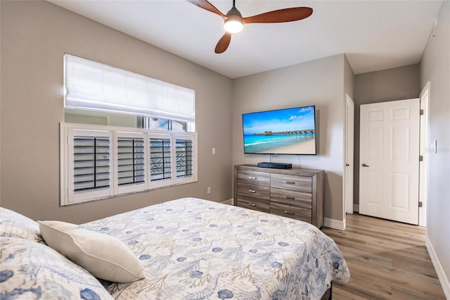 bedroom with a ceiling fan, baseboards, and wood finished floors