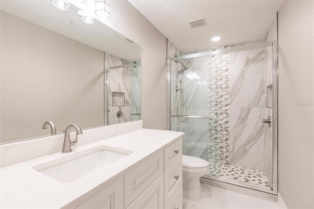 bathroom featuring vanity, a shower with shower door, and toilet