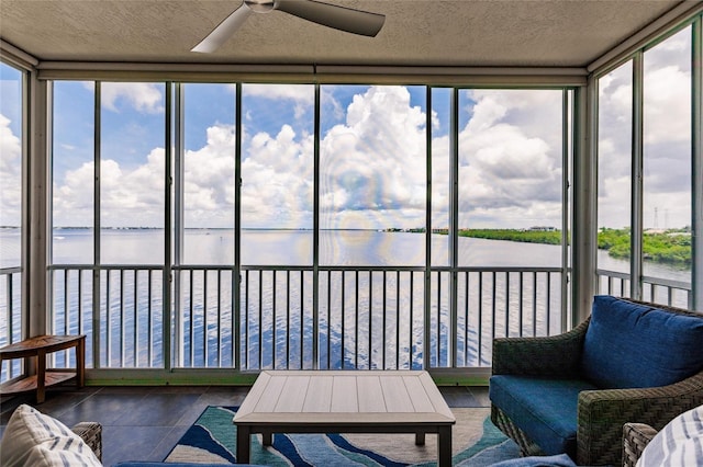 sunroom / solarium with a water view and ceiling fan