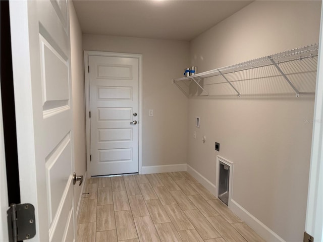 clothes washing area featuring hookup for a washing machine, wood tiled floor, hookup for an electric dryer, laundry area, and baseboards