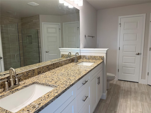 bathroom featuring double vanity, a shower stall, and a sink