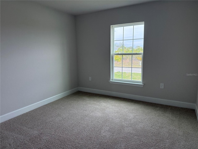 carpeted spare room with baseboards