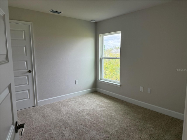 carpeted empty room with baseboards and visible vents