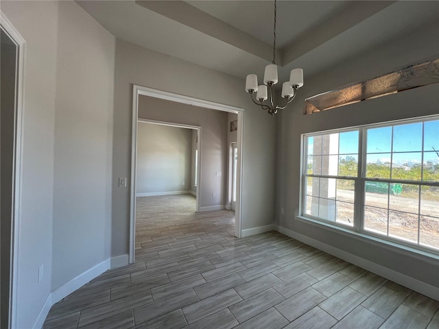 unfurnished dining area with baseboards, wood finish floors, a raised ceiling, and a notable chandelier