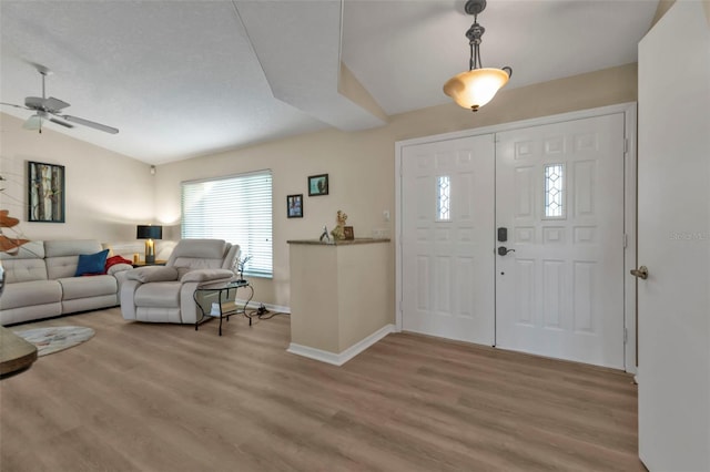 foyer featuring ceiling fan, light hardwood / wood-style floors, and lofted ceiling