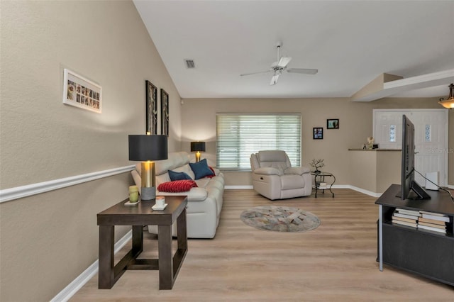 living room featuring ceiling fan, lofted ceiling, and light wood-type flooring