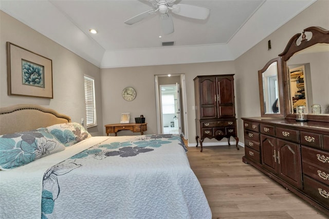 bedroom featuring ceiling fan, light hardwood / wood-style floors, and ensuite bath