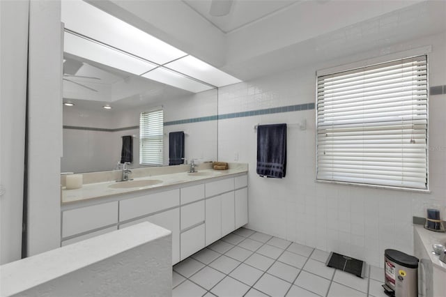 bathroom with ceiling fan, tile patterned flooring, vanity, and tile walls