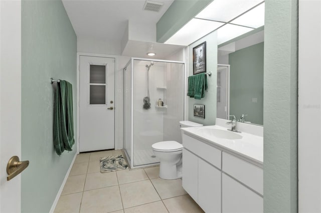 bathroom with tile patterned flooring, vanity, a shower with shower door, and toilet