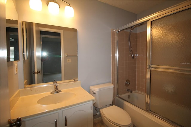 full bathroom featuring combined bath / shower with glass door, vanity, and toilet