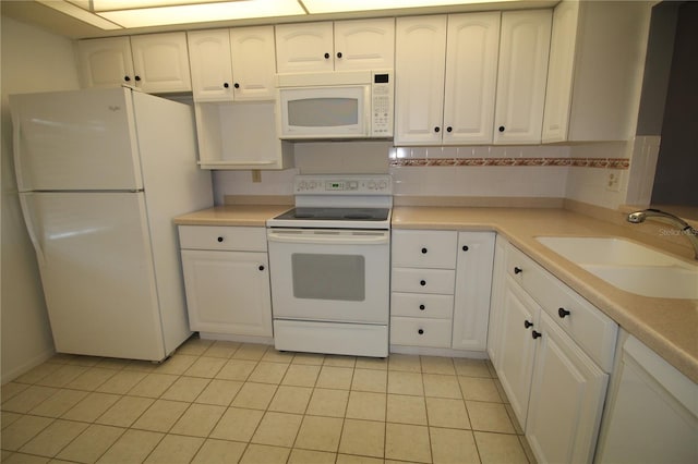 kitchen with light tile patterned flooring, sink, white cabinetry, backsplash, and white appliances