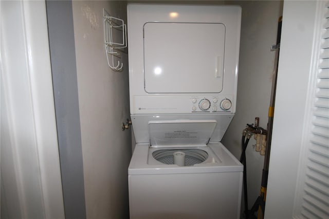 clothes washing area featuring stacked washing maching and dryer