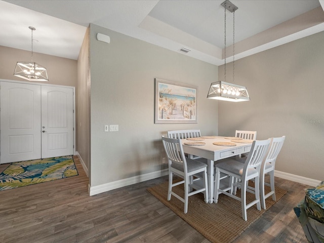 dining area with dark hardwood / wood-style flooring and a notable chandelier