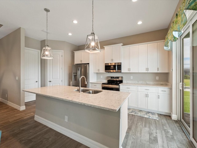 kitchen with an island with sink, stainless steel appliances, white cabinetry, and dark wood-type flooring