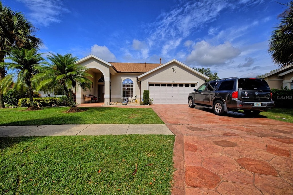 single story home with a garage and a front yard