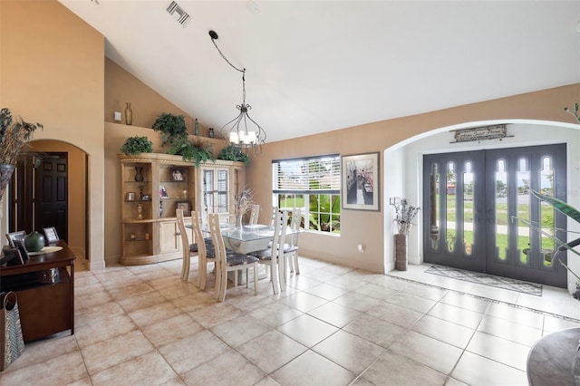 tiled dining space with an inviting chandelier and high vaulted ceiling