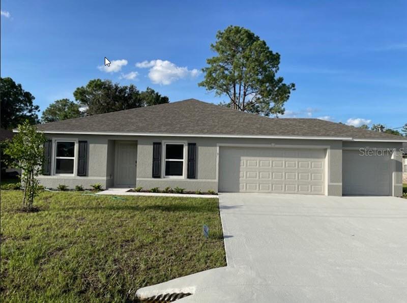 single story home with a garage and a front lawn