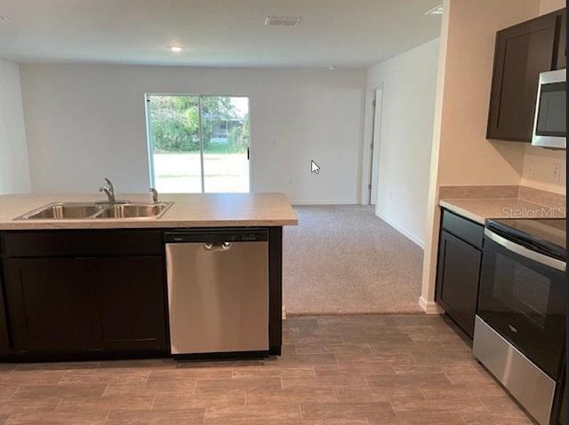 kitchen with light carpet, sink, and stainless steel appliances