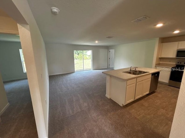 kitchen with dark carpet, sink, a kitchen island with sink, white cabinetry, and stainless steel appliances