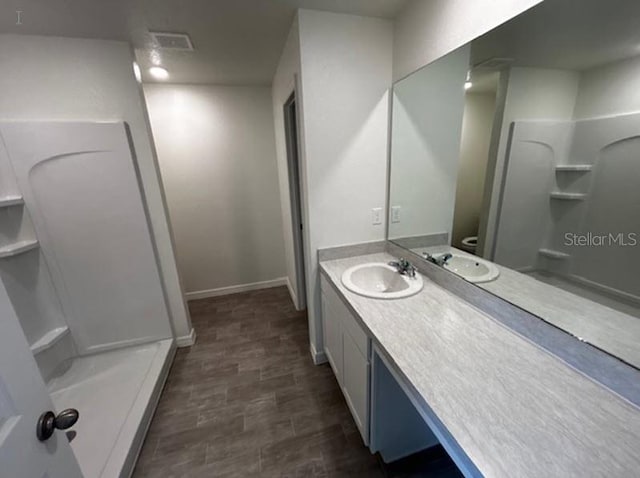 bathroom with walk in shower and vanity