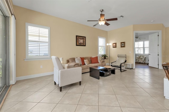 living room featuring light tile patterned flooring, ceiling fan, and a wealth of natural light