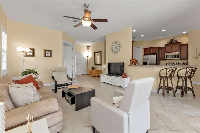 living room with light tile patterned floors, ceiling fan, baseboards, and recessed lighting