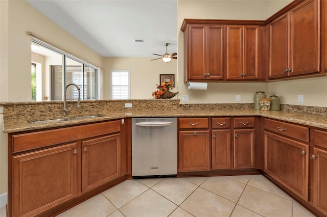 kitchen featuring light stone counters, dishwasher, sink, and light tile patterned flooring