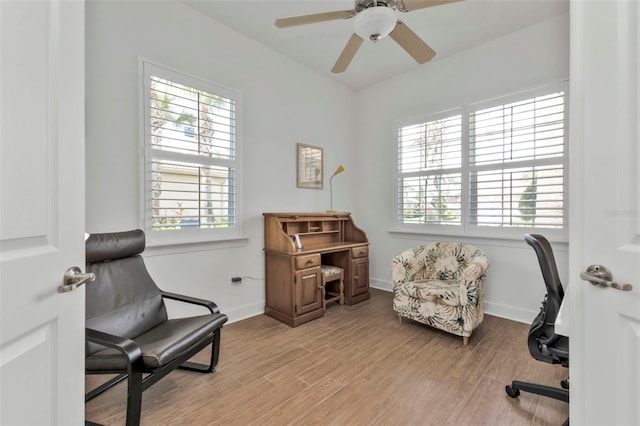 sitting room with baseboards, a ceiling fan, a wealth of natural light, and light wood-style floors